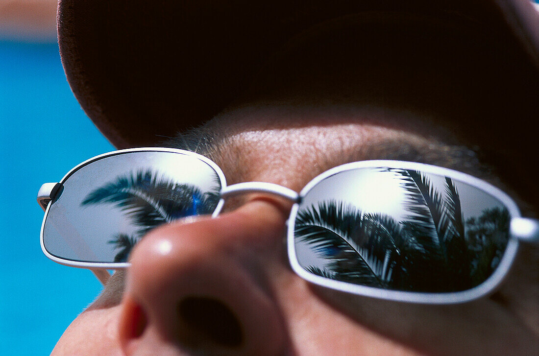 Reflection of a palm tree in Sunglasses, Forte Village, St. Margherita di Pula, Sardinia, Italy