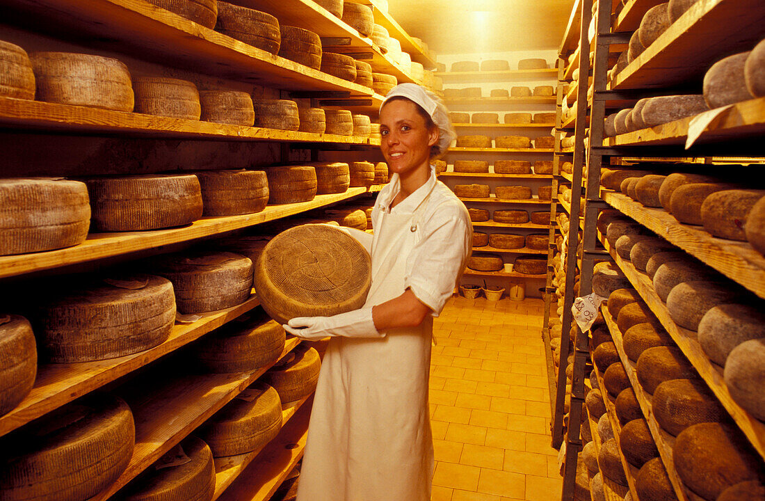 Frau zeigt stolz Käselaib, Pecorino Käserei,  Pecorino Cugusi, Pienza, Toskana, Italien