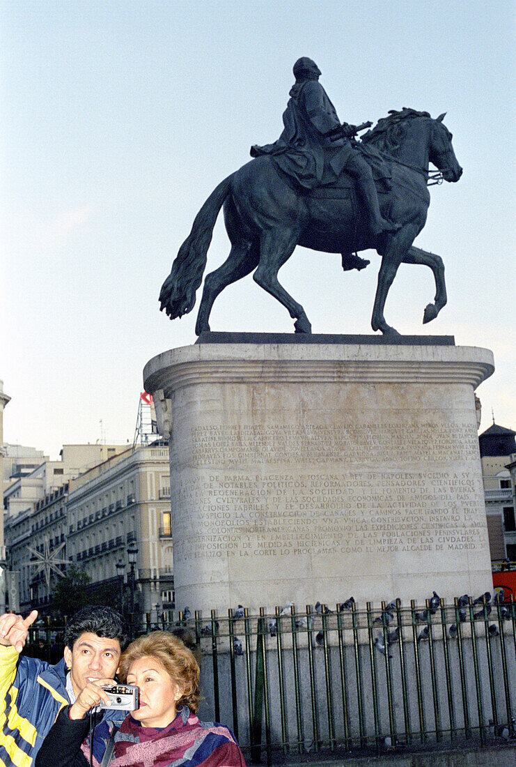 Touristen mit Fotoapparat vor einer Reiterstatue, Puerta del Sol, Madrid, Spanien, Europa