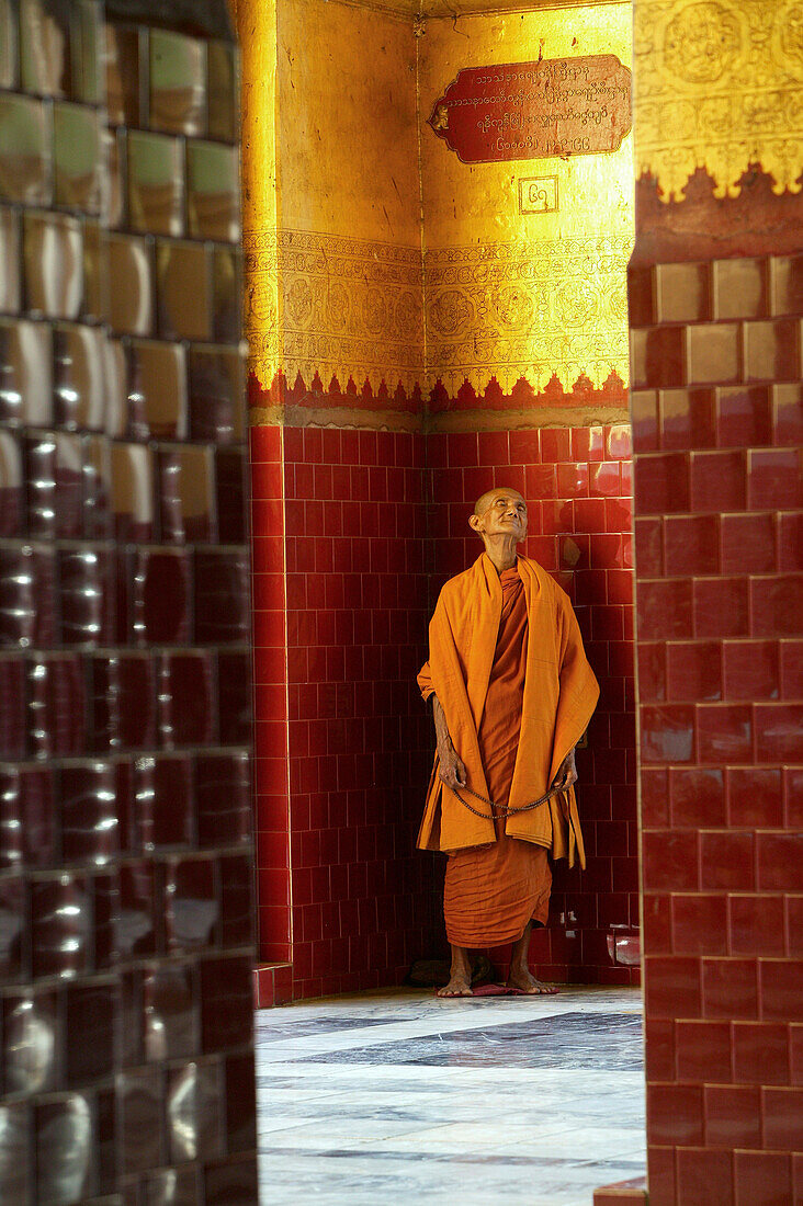 Alter Mönch betet in einer Ecke der Mahamuni Pagode, Mandalay, Myanmar, Burma, Asien