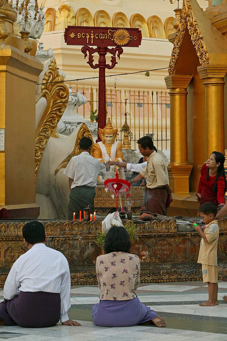 Shwedagon Pagoda, Burma, Myanmar, Burmese praying, An den roten Pfosten werden die acht Planetengötter verehrt