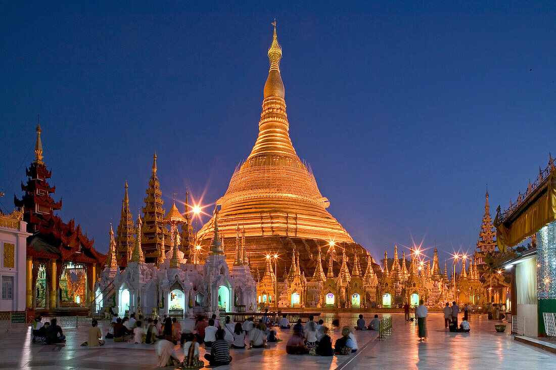 Menschen vor der beleuchteten Shwedagon Pagode am Abend, Myanmar, Burma, Asien