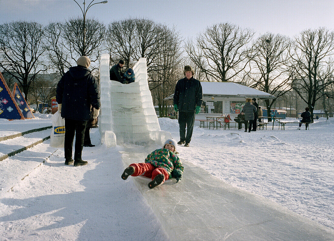 Kind auf Eisrutsche im Gorki Park, Moskau, Russland