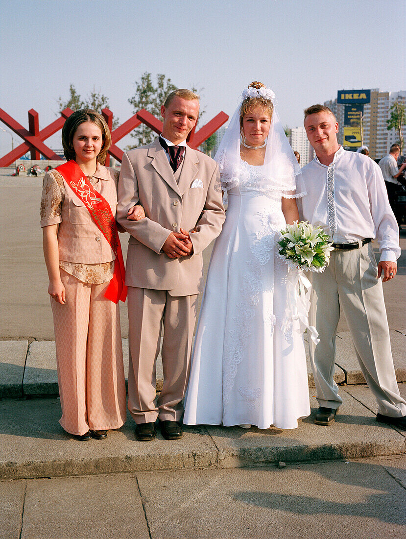 Zwei frischvermählte Paare posieren vor dem Kriegsdenkmal, Khimki, Moskau, Russland