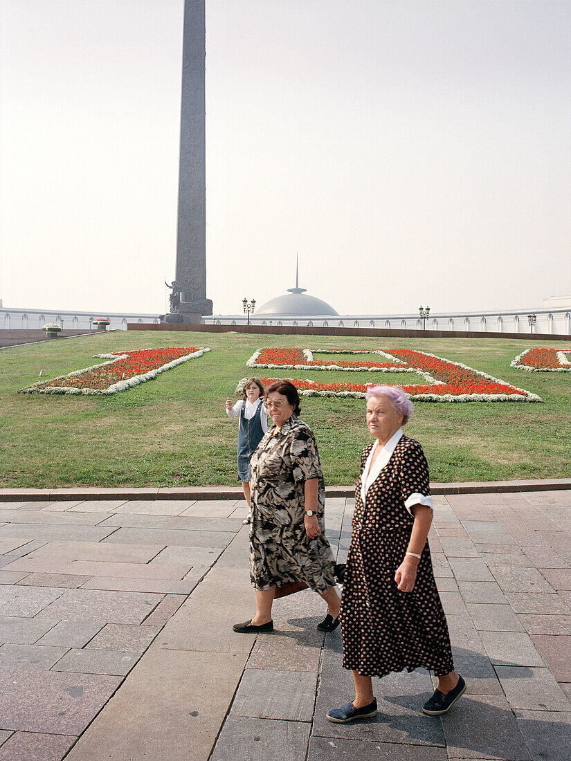 Two women in front of war memorial at Victory Park, Moscow, Russia