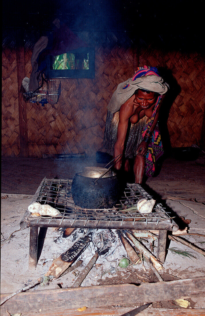 Huli Frau kocht in Huette, Huli woman cook in her h, Huli woman cook in her hut