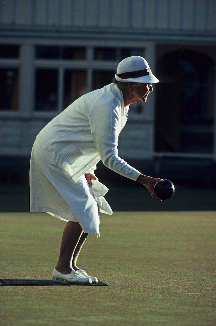 Bowling lady in white uniform, Lawn bowls, popular outdoor sport, in New Zealand