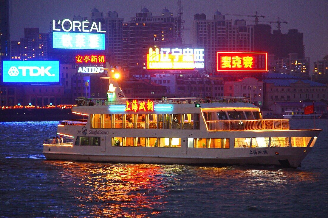 Beleuchtetes Ausflugsschiff auf dem Fluss am Abend, Shanghai, China, Asien
