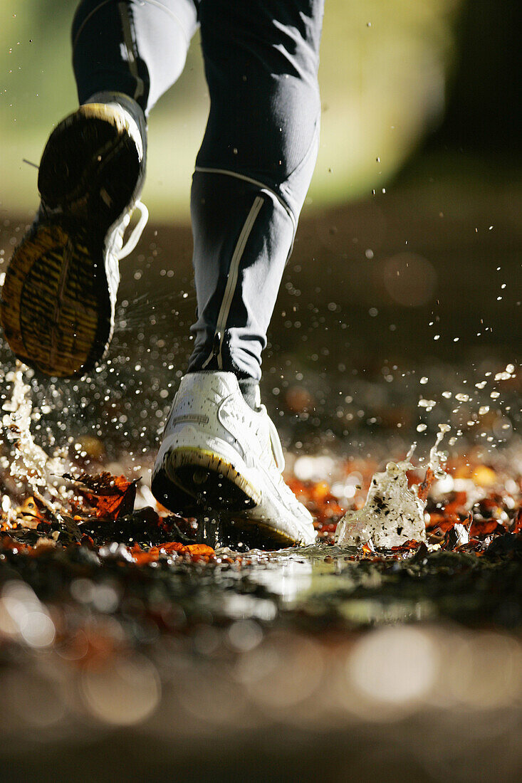 Man running through a puddle, Voralpenland, Germany