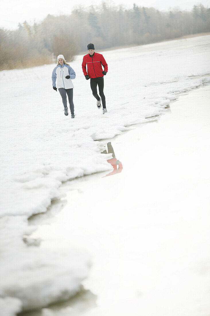 Young couple running at lake