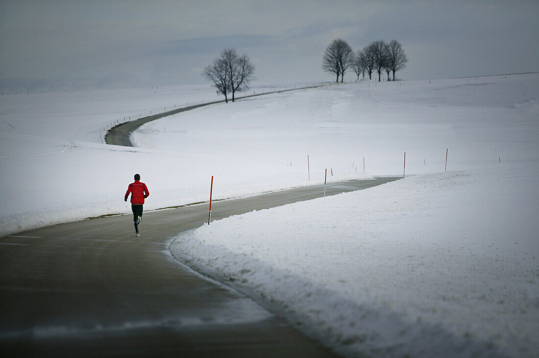 Young man running on country road