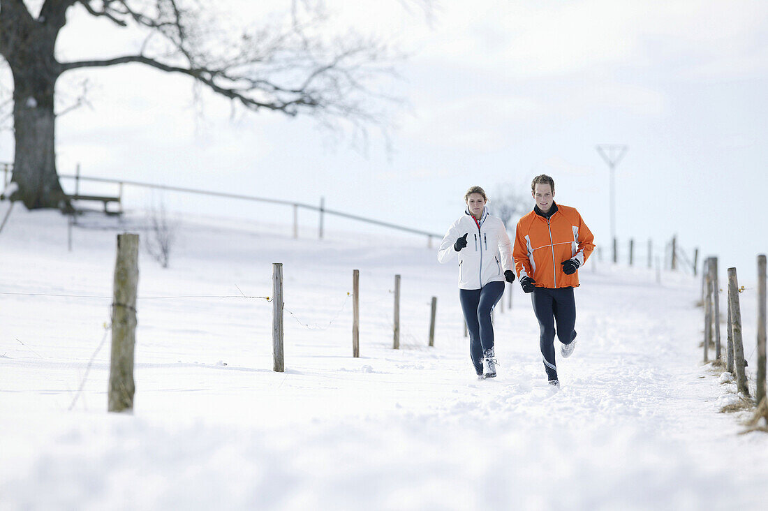 Young couple running on track