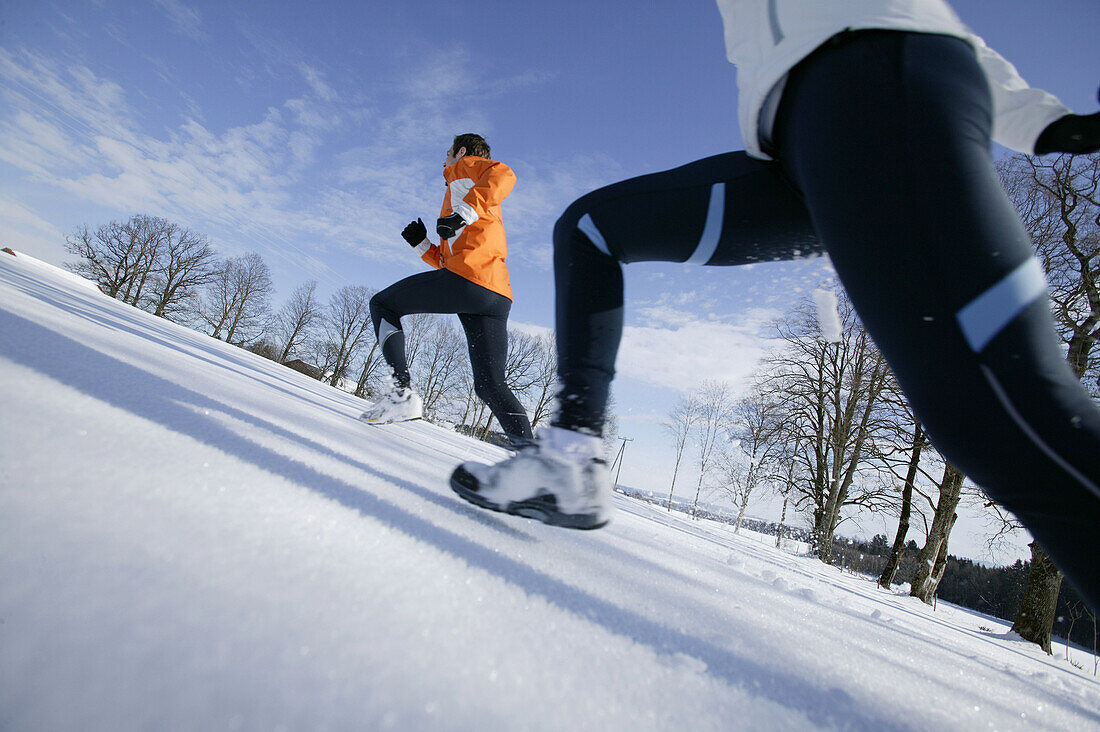 Young couple running on snow