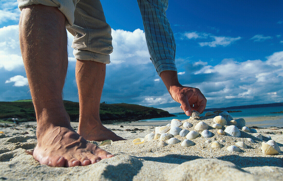 Mann sucht Muscheln am Strand, Herm, Kanalinseln, Großbritannien