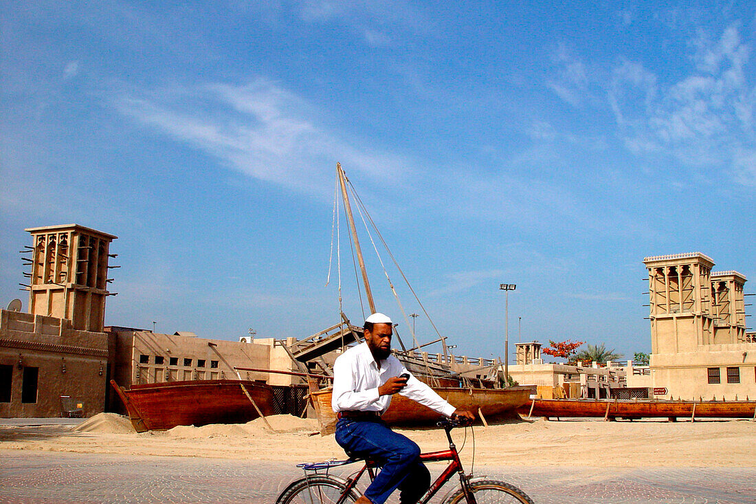 Man on bicycle with mobile, Bur Dubai, Dubai, United Arab Emirates, UAE