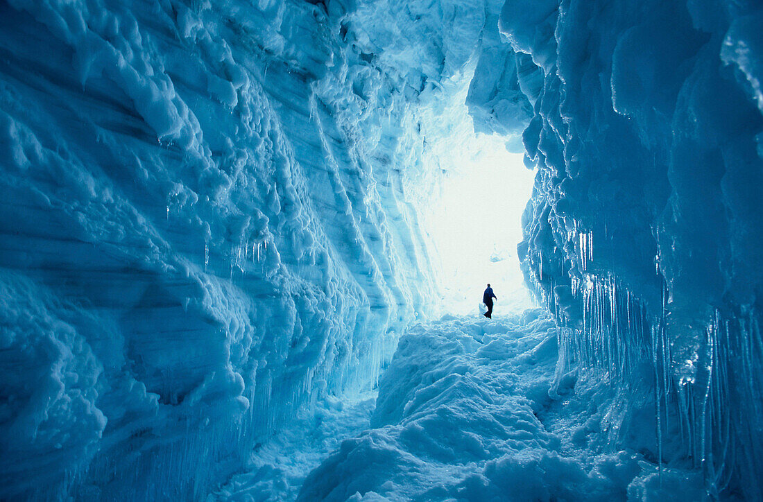 Mountain guide walking through an ice crevice, Am Brokarjoekull, a glacial tongue of the Vatnajoekull, Island
