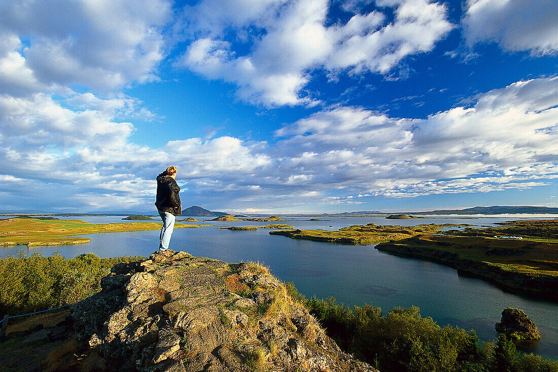 Man standing on a rock looking at the view, Myvatn, North Island, Island