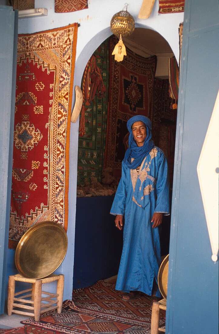 Ibrahim, Berber standing at the entrance to a house wearing traditional clothing, Berber Apartment with Hand of Fatima, Tafraoute, Anti-Atlas, Marocco
