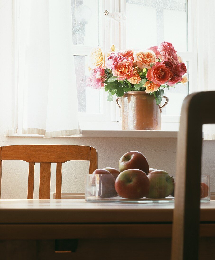 A colourful bunch of roses on a sunny window sill