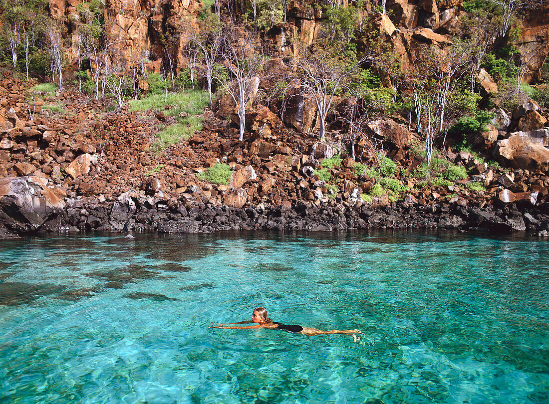 Woman Swimming in natural pool, Galapagos Islands, Ecuador