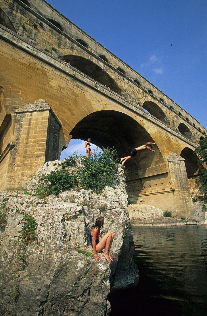 Kinder springen von einem Felsen ins Wasser, Pont du Gard, Provence, Frankreich