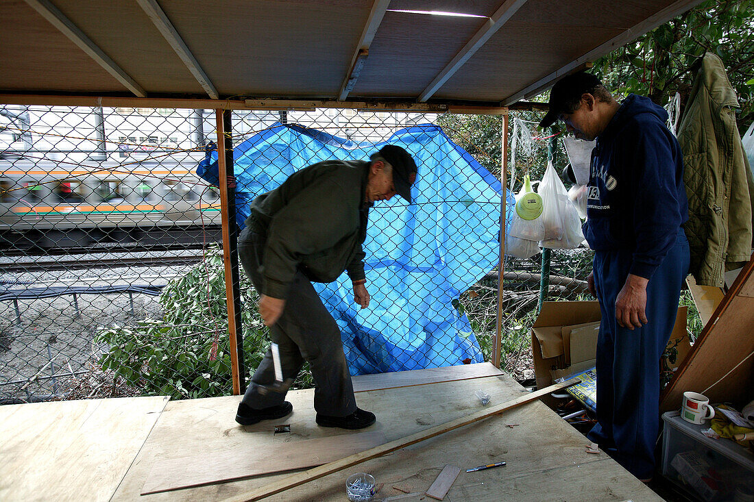 Homeless, living boxes in Tokyo-Shibuya, Japan, Homeless community on a car park roof in Shibuya, building with plywood a self made shelter, neighbourhood help, architecture of cardboard boxes, blue fabric sheets Obdachlose, notduerftige Schutzbauten, Pap