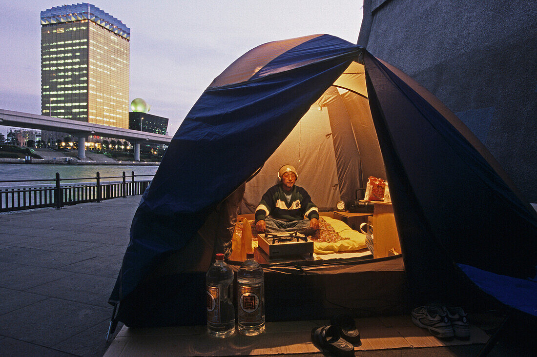 Homeless, living boxes in Tokyo, Japan, Homeless community on the Sumida River banks, newcomer in a camping tent Obdachlose, notdürftige Schutzbauten, Pappkarton-Architektur, Plastikplanen, Slum, Obdachlosigkeit, Randgruppe, Astronomical high rents have c