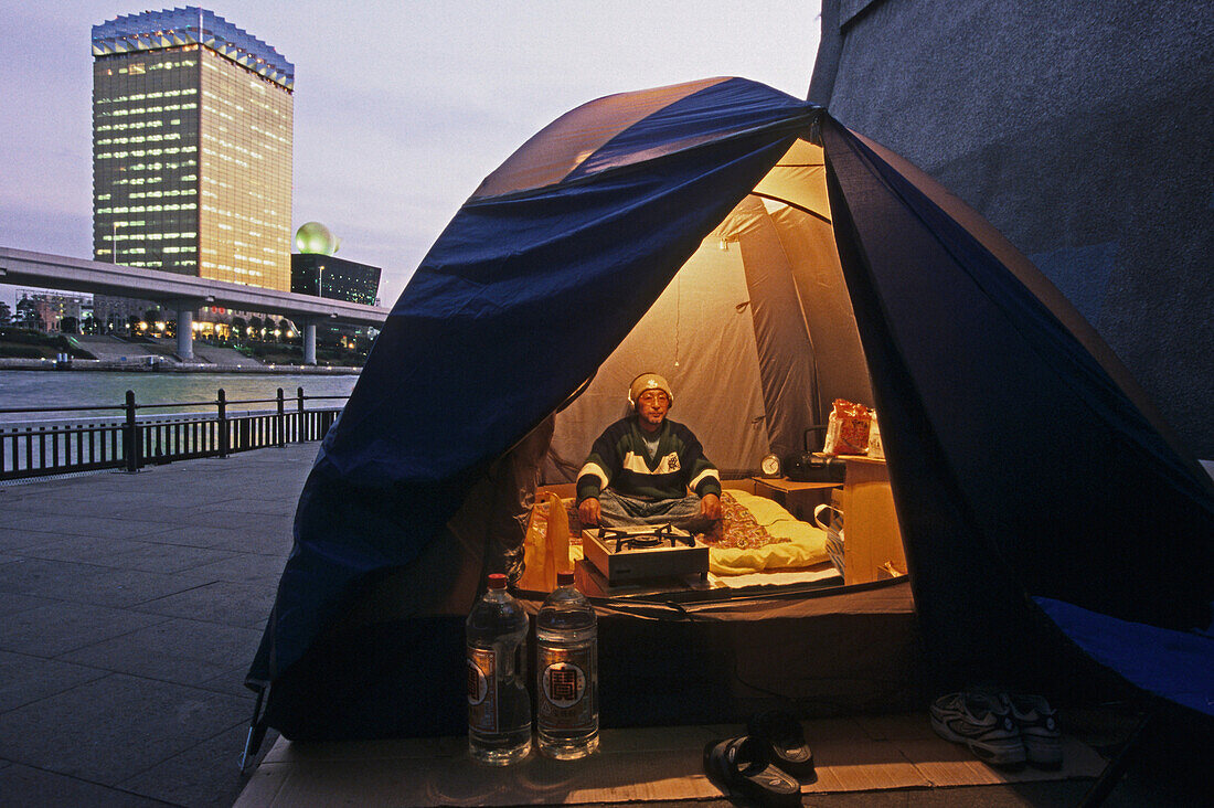 Homeless newcomer in camping tent, Sumida River banks, Tokyo
