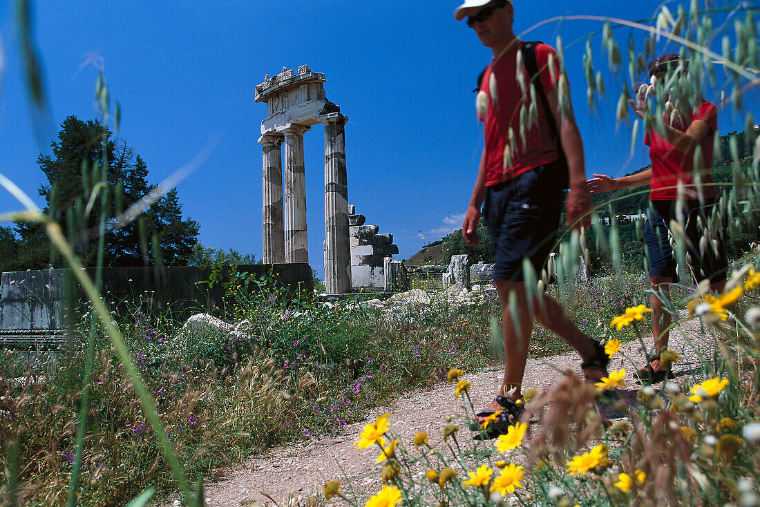 Visitors at the Tholos temple, at the sanctuary of Athena Pronaia, Delphi, Peloponnese, Greece