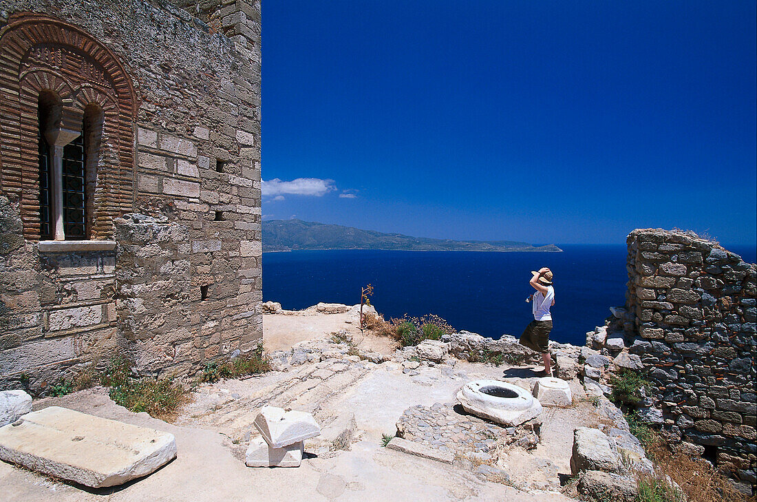 Woman standing at byzantine church Agia Sofia, Monemvasia, Peloponnese, Greece