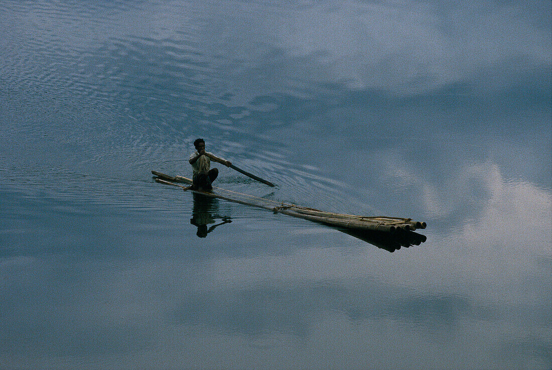 Man on a selfmade long boat, Kerala India