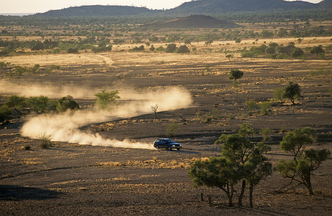 Schotterstraße mit Staubwolke nähe Winton, Maltilda Highway, Queensland, Australien