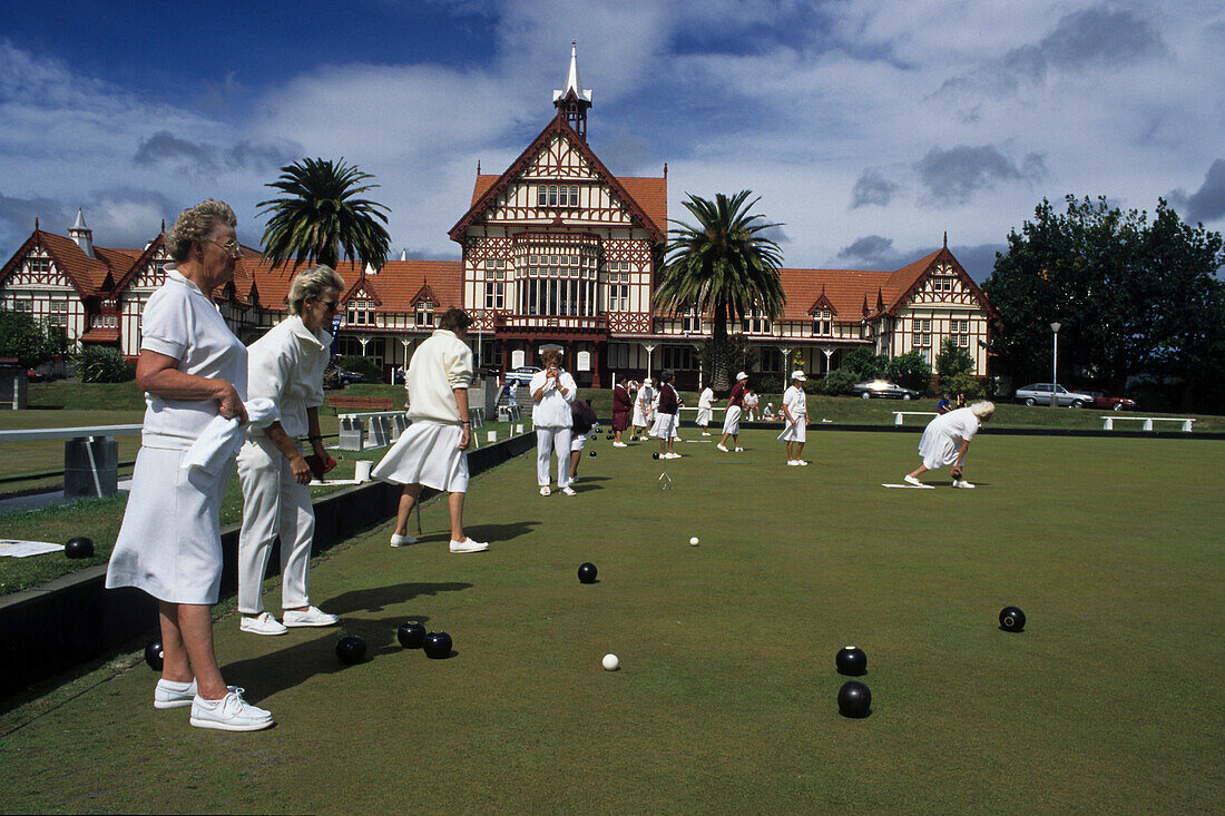 Dame in weißen Uniformen spielen Bowling auf Rasen vor Kurhaus, Rotorua, Nordinsel, Neuseeland
