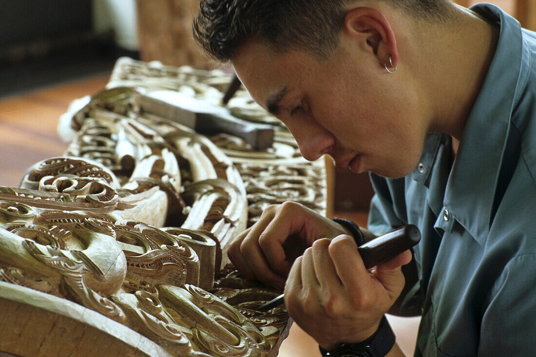 Einer junge Mann arbeitet mir Holz, Maori Holzschnitzerei, Rotorua, Institut für Kunst und Handwerk der Maori, Whakarewarewa, Nordinsel, Neuseeland