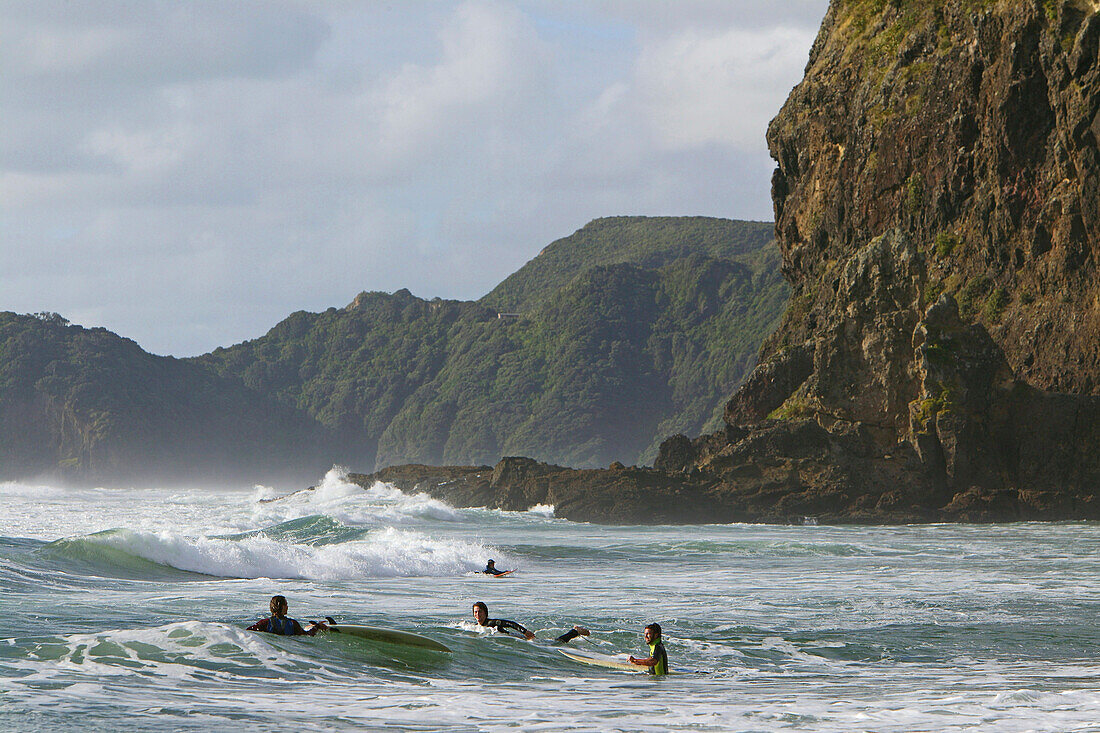 Surfers, Piha surf beach, Piha Beach and Lion Rock, west coast near Auckland