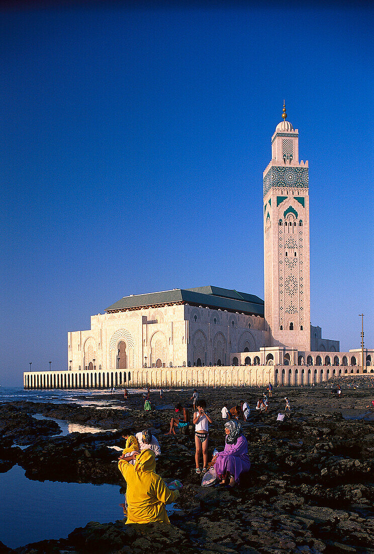Menschen am Riff und Moschee Hassan II unter blauem Himmel, Casablanca, Marokko, Afrika