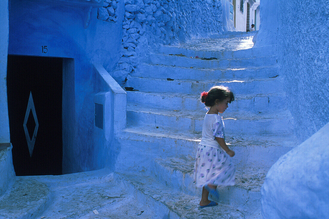 Little girl on stairs in an alley, Chefchauen, Morocco, Africa