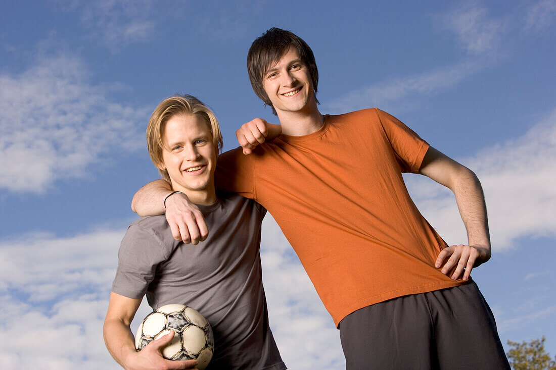 Two male soccer players standing arm in arm
