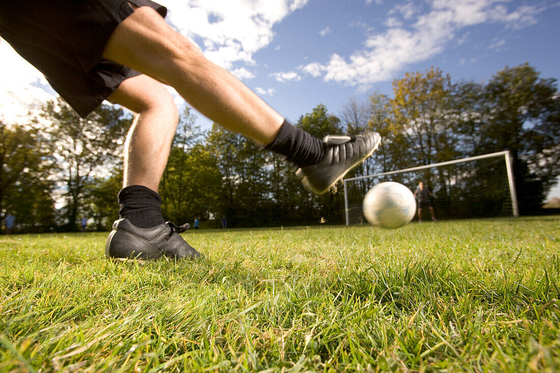 Young soccer player kicking the ball