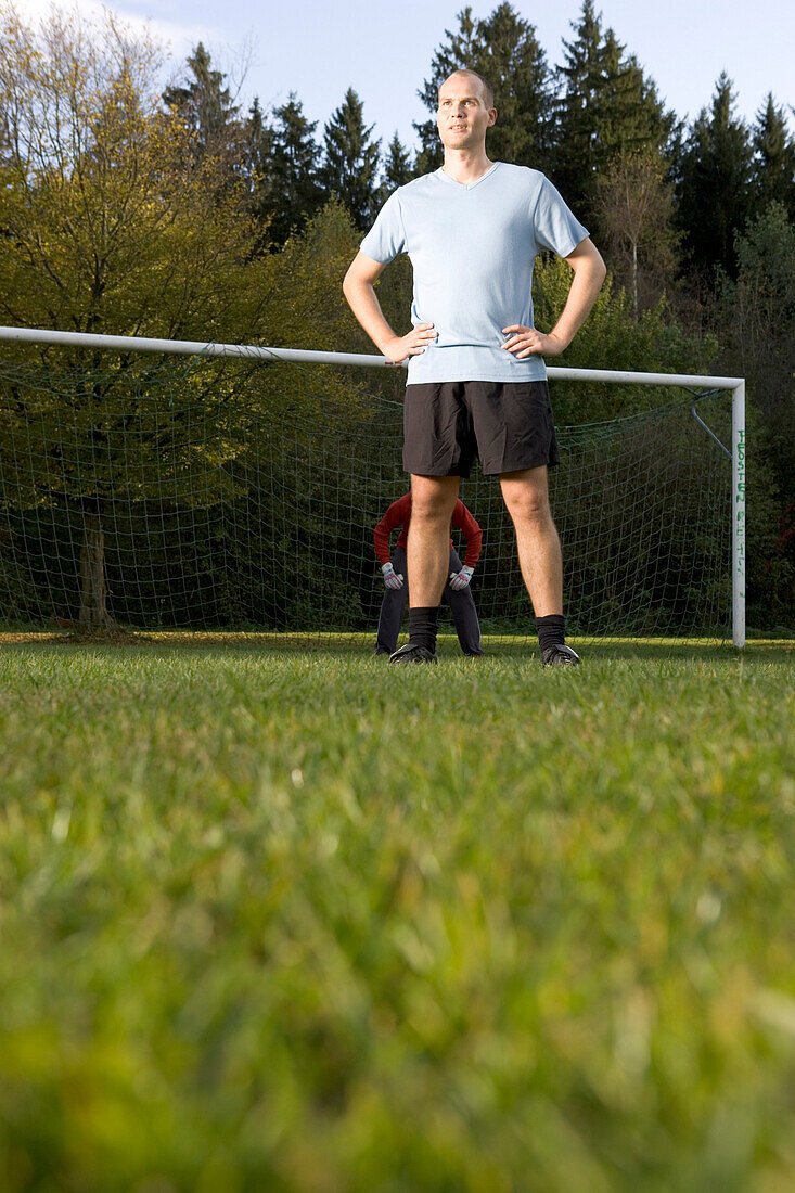 Young man on soccer field, hand on the hip