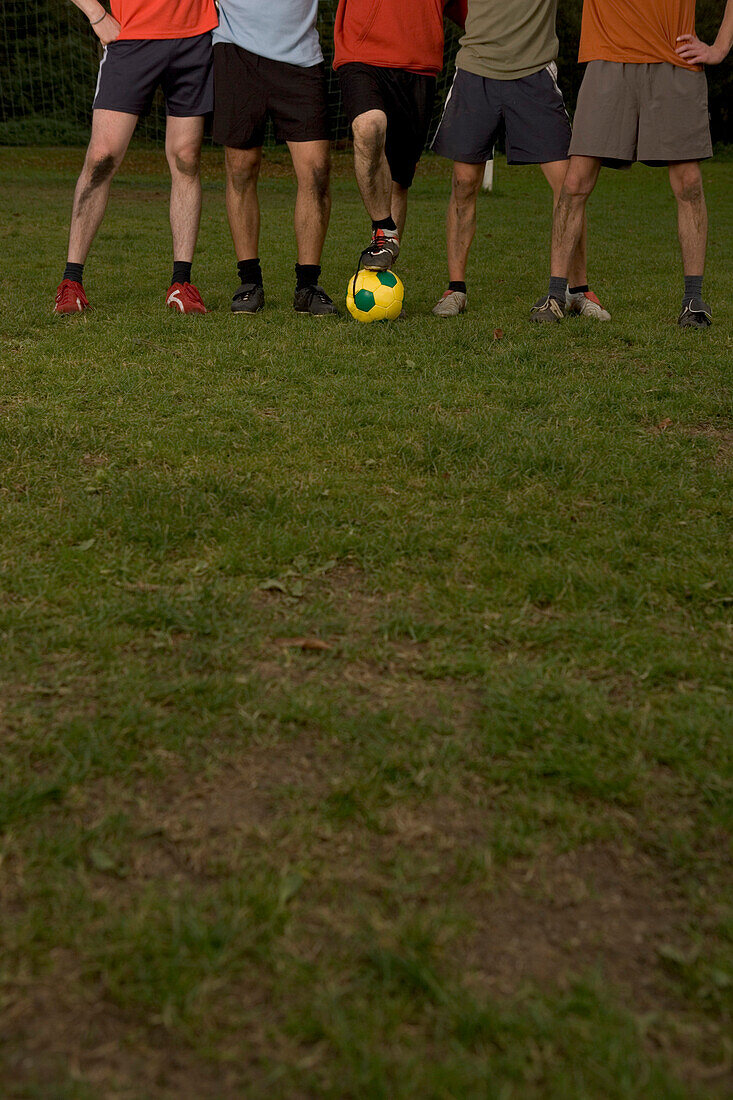 Legs of five young male soccer players, standing in a row