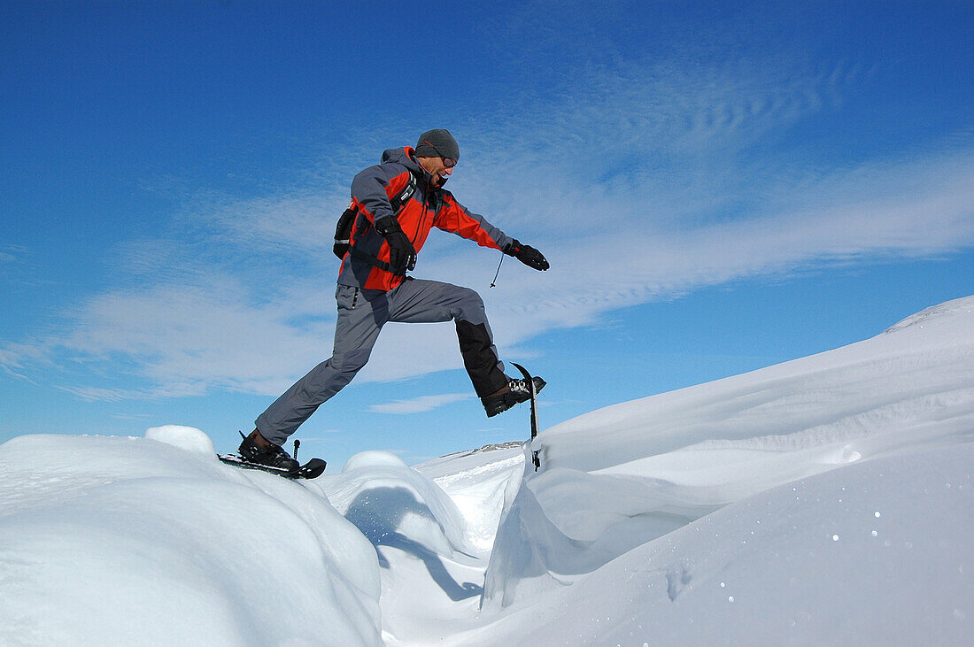 Man snowshoeing though deep snow, Ilulissat, Greenland