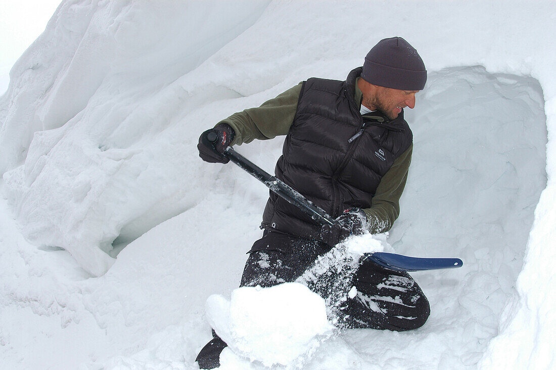 Junge Mann baut eine Schneehöhle, Ilulissat, Grönland