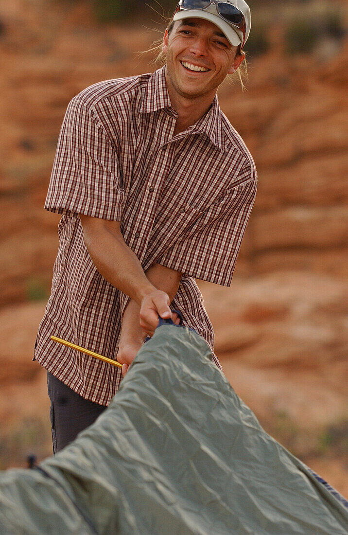 A man putting up a tent, Camping, Lake Powell, Arizona, USA