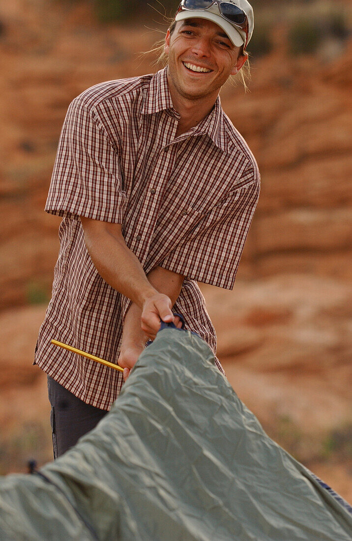 Ein Mann baut ein Zelt auf, Camping, Lake Powell, Arizona, USA