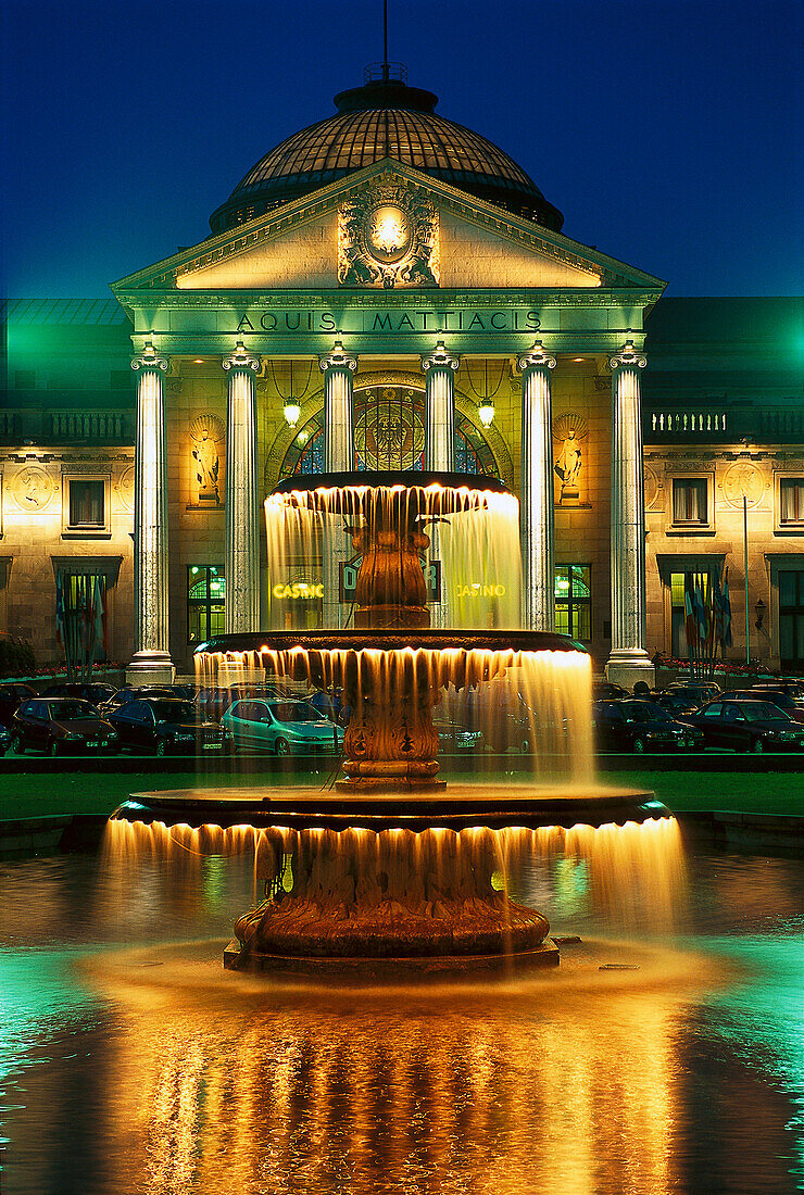 Fountain and illuminated spa hotel at night, Wiesbaden, Germany, Europe