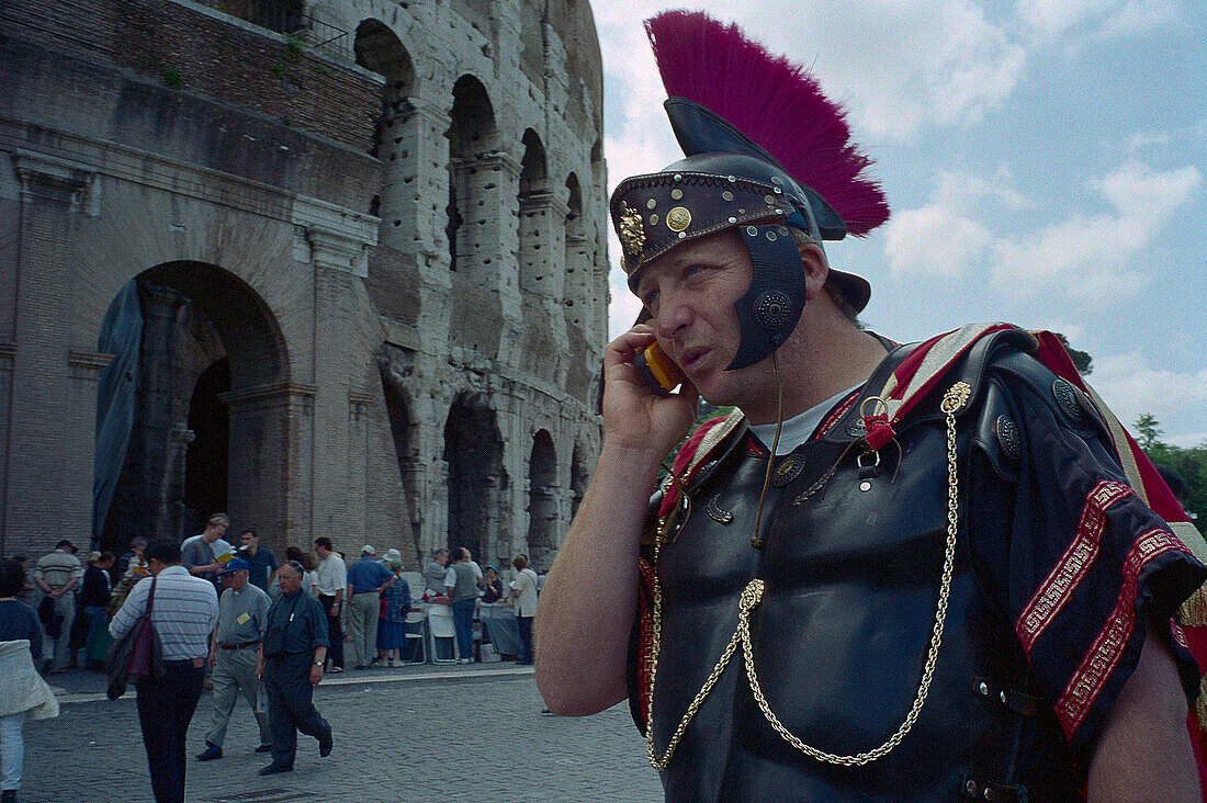 Legionnaire with mobile phone in front of the Colosseum, Rome, Latium, Italy, Europe