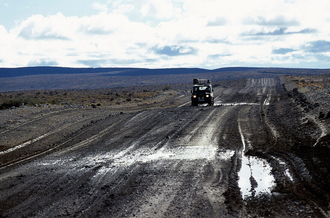 Car on road in lonesome landscape, Rio Mayo, Argentina, South America, America