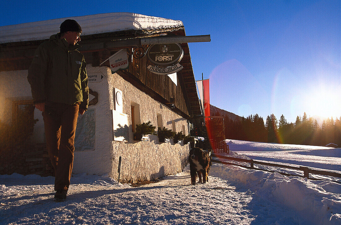 Mann ermuntert seinen Hund zum Spazierengehen, Huberalm, Antholz, Pustertal, Südtirol, Italien