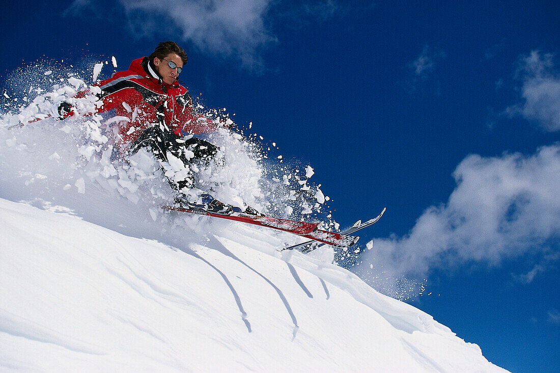 Freeskiing, Skifahrer auf verschneitem Hang im Sonnenlicht